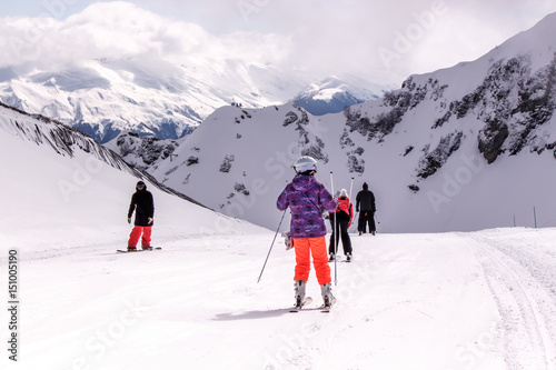 skiers and snowboarders on the slope in the mountains