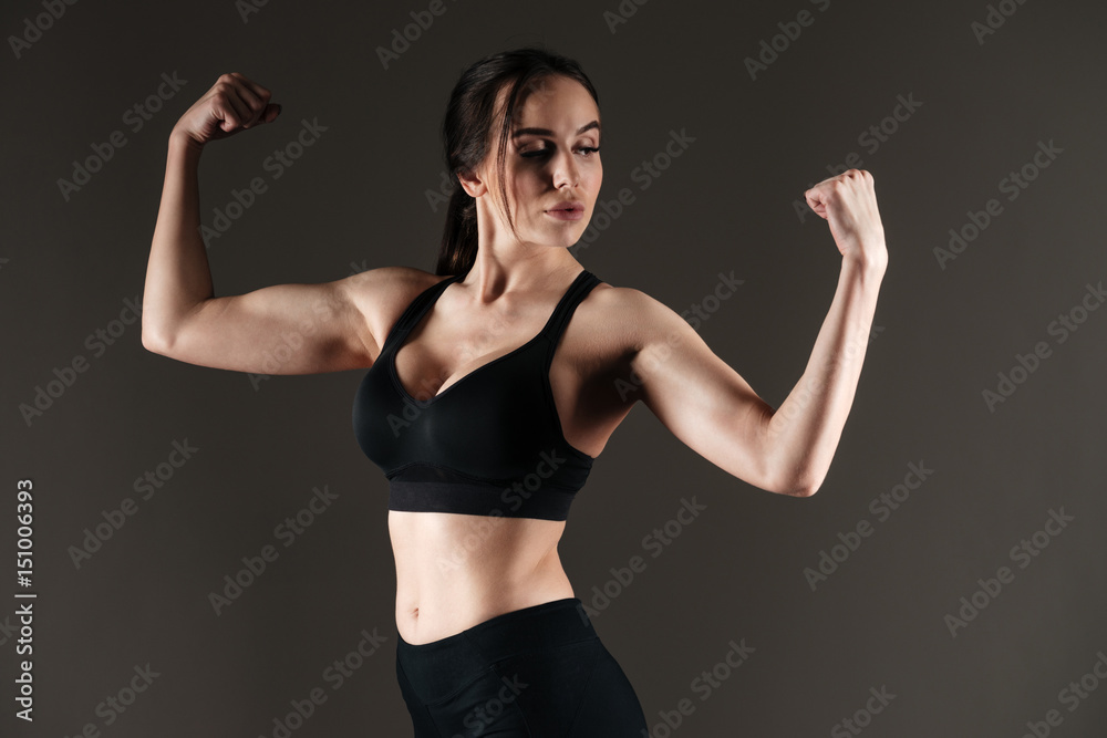 Serious strong sportswoman showing biceps Serious strong sportswoman showing biceps