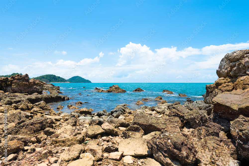 Yello rock and sea with blue sky.