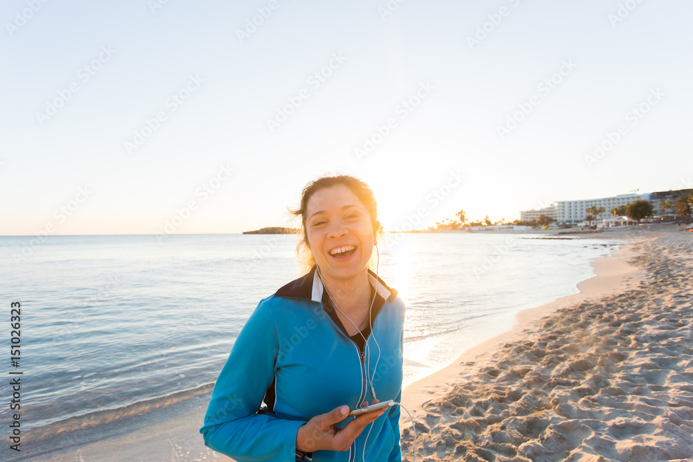 sport and lifestyle concept - woman after running with earphones outdoors