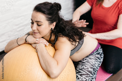 Pregnant woman getting a back massage from her midwife photo