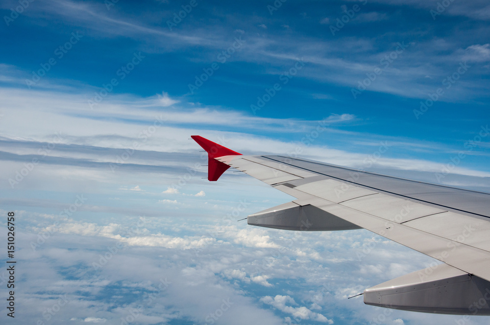 When looking through the window while on a plane. You can see the sky and clouds of airplane wings.  - Concept clouds, plane, sky.