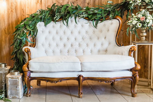 Luxury festive wedding decoration with flowers, vintage sofa and candles.