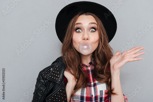 Cute funny girl in hat chewing bubble gum