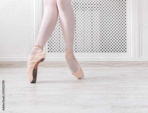 Ballerina in pointe shoes, graceful legs, ballet background