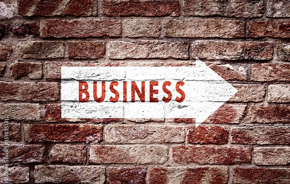 Fototapeta premium Business arrow sign on aged brick wall background. Conceptual company direction symbol. 