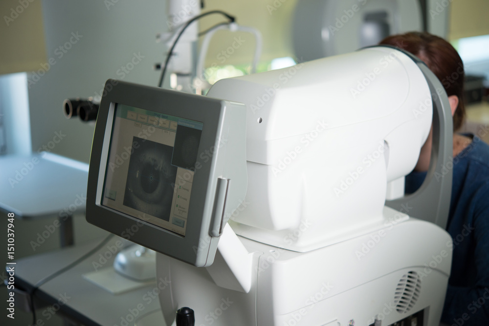 Fototapeta premium The ophthalmologist conducts the research with the help of various equipment, a contactless tonometer, for the diagnosis of eye disease