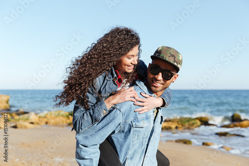 Happy african loving couple walking outdoors at beach © Drobot Dean