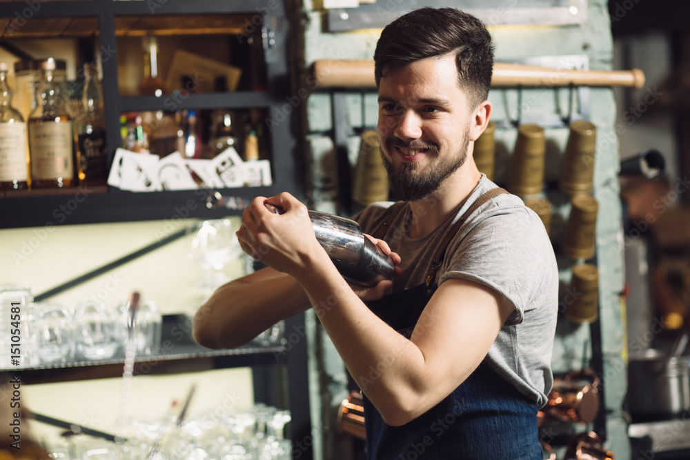 Young male bartender preparing an alcohol cocktail