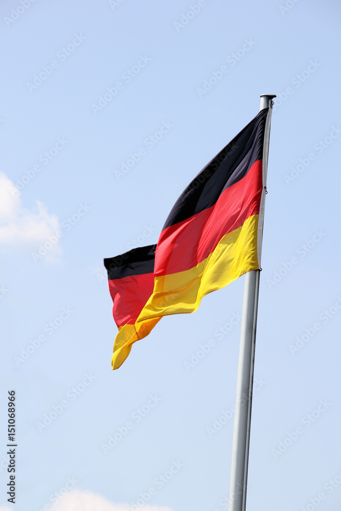 Swinging German flag against blue sky Swinging German flag against blue sky