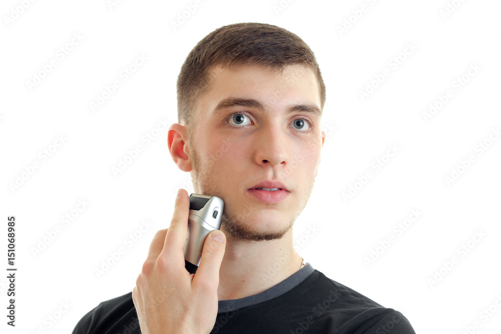Portrait of a charismatic guy who shaves his beard trimmer close-up Portrait of a charismatic guy who shaves his beard trimmer close-up