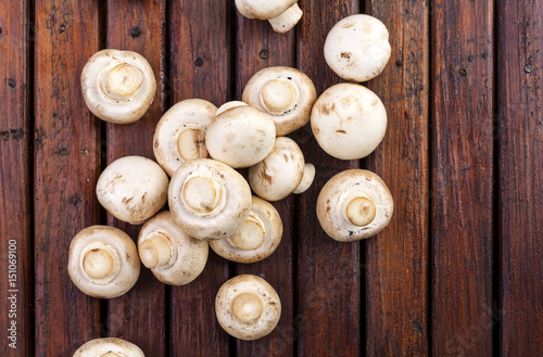 Mushrooms champignon on wooden background. Top view. Copy space.