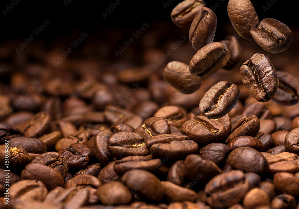 Obraz premium Spadające ziarna kawy. Ciemne tło z miejsca na kopię, zbliżenie