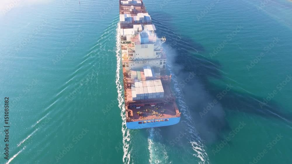 Aerial view of container ship passes through the channel goes into the open ocean after loading in the port of China at full speed. 4K. Aerial view of container ship passes through the channel goes into the open ocean after loading in the port of China at full speed. 4K.