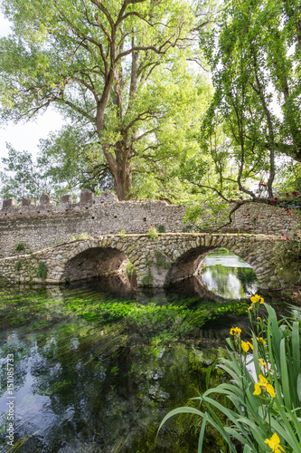 Ancient bridje on the crystalline wather in the Garden of Ninfa in the province of Latina, Italy, Europe photo