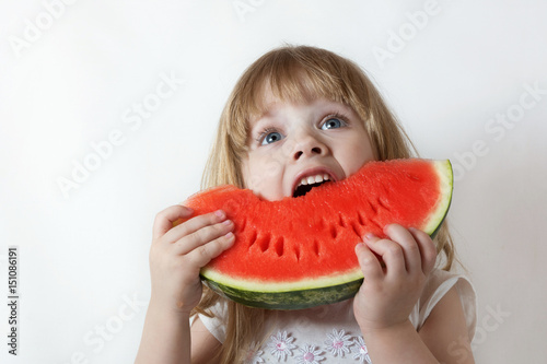 little blonde girl eating a piece of watermelon