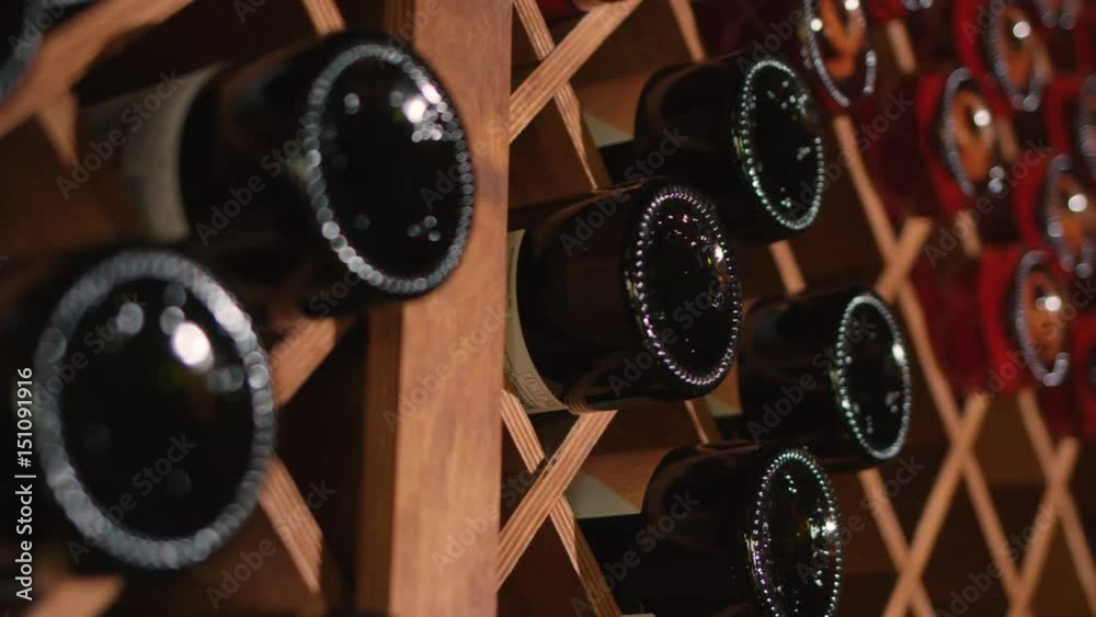 Attractive sommelier coming to the room with wine and choosing the best one for the clients. Slow motion.