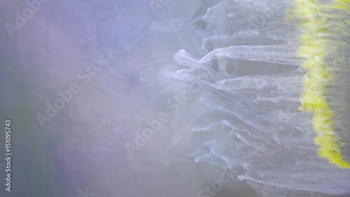 Yellow ink spreading in water abstract background texture slow motion
