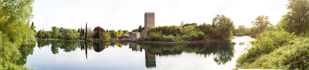 View of the historical castle and spectacular lake of the Garden of Ninfa in the province of Latina, Italy, Europe