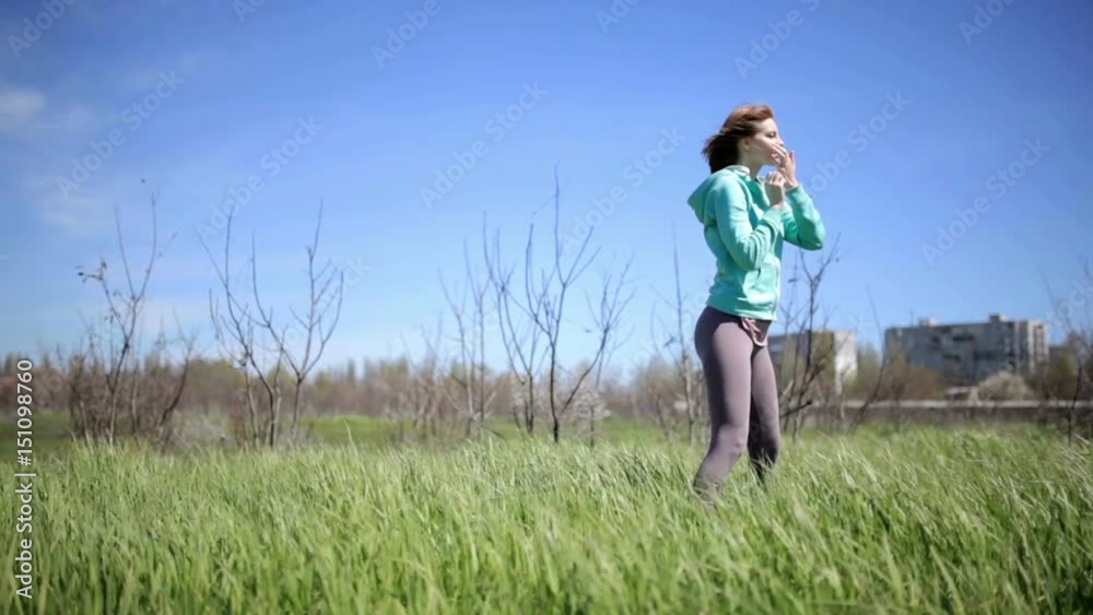Beautiful young woman practices yoga moves and positions outdoors in green grass Beautiful young woman practices yoga moves and positions outdoors in green grass