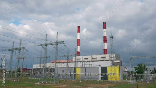 Time-lapse sky cloud above a turbine power plant producing electricity, which is transmitted by wires on electric supports, 4k