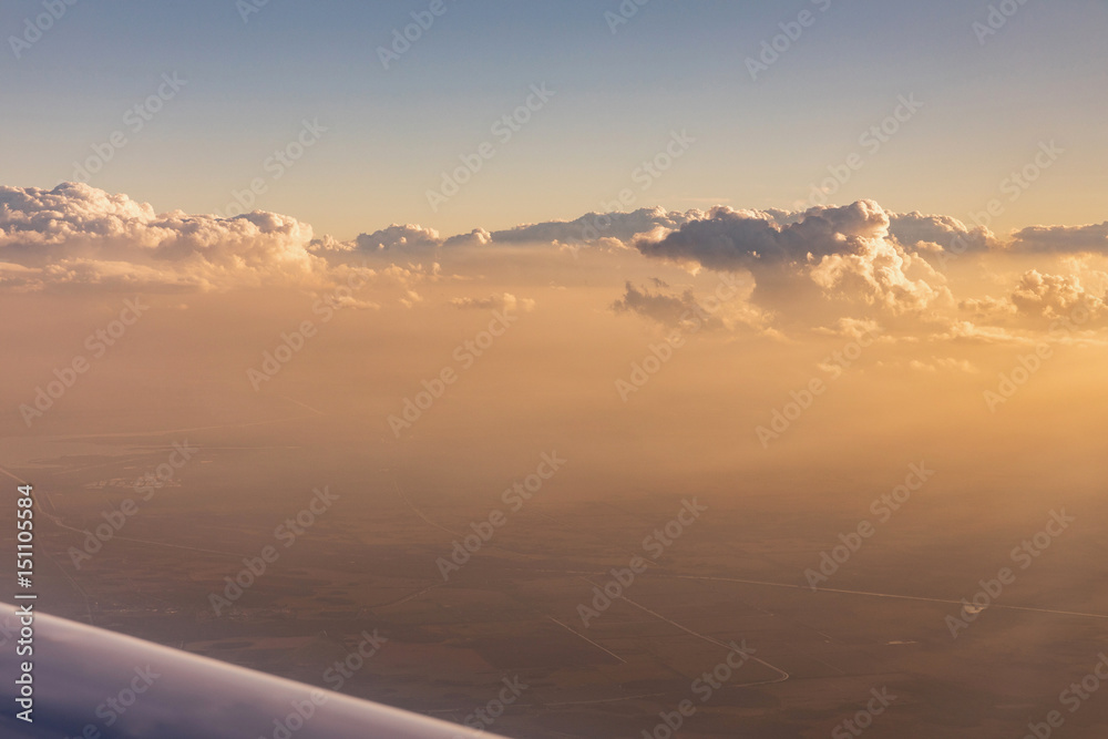Aerial view of golden clouds lit by the evening sun over Florida, view from the aircraft during the flight.