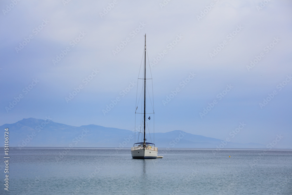 Sailing boat on a blue sea background
