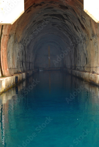 Concrete bunker shelter for submarines in adriatic sea. Beautifull clear blue water sea.