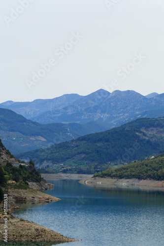 Fototapeta Naklejka Na Ścianę i Meble -  Mountains covered by pine forests descending to lake