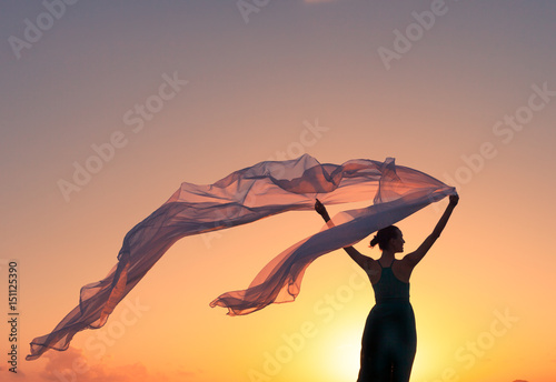 Feeling free! Female holding a silk cloth blowing in the wind. 