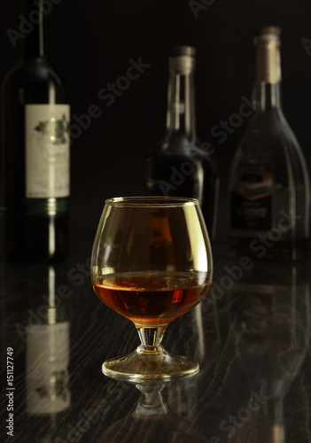 Glass with white, red wine and cognac or whisky on mirror table. Celebrities composition. selective focus