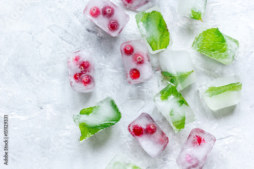 fresh cranberry in ice cubes on gray stone background top view