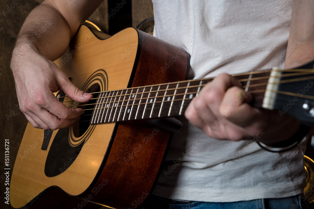 Fototapeta premium Playing guitar. Acoustic guitar in the hands of the guitarist. Horizontal frame