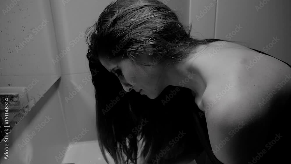 Woman with strong makeup washing face crying desperate slow motion black and white