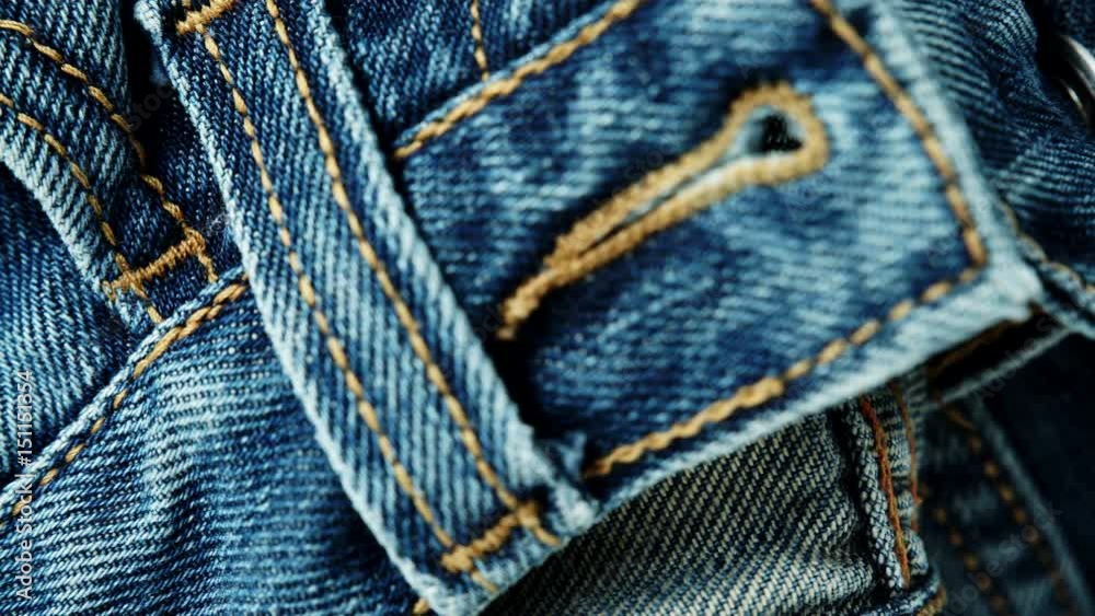 Closeup detail of blue denim jeans belt loop and pocket, texture background. Dolly sliding shot 4K ProRes HQ codec Closeup detail of blue denim jeans belt loop and pocket, texture background. Dolly sliding shot 4K ProRes HQ codec