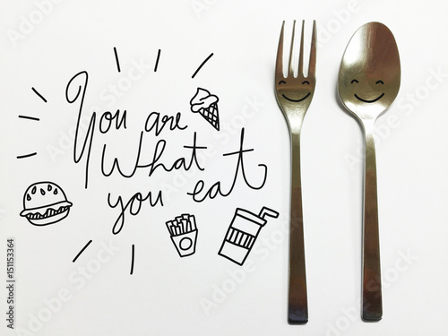 You are what you eat word lettering and fast food icon on spoon and fork background