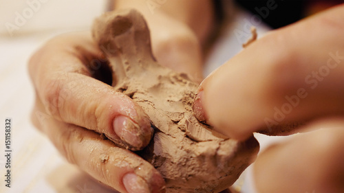 Female sculptor is modeling clay figurine or creating pottery ceramics statuette. Art and handicraft modelling creation.