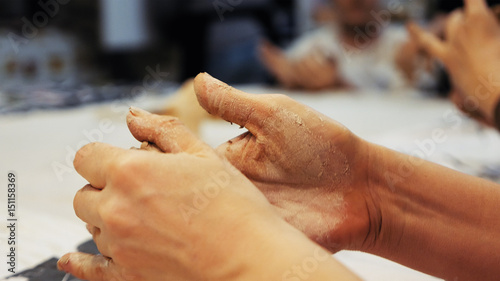 Female sculptor is pugging and kneading clay for creating pottery ceramics. Art and handicraft modelling creation.