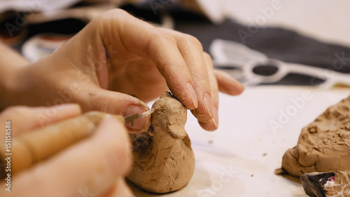 Female sculptor is modeling clay figurine or creating pottery ceramics statuette. Art and handicraft modelling creation.