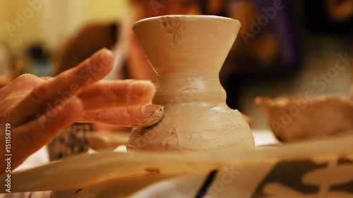 Child ceramist sculptor is modeling clay pot or ceramics vase bowl. Art and handicraft modelling creation.