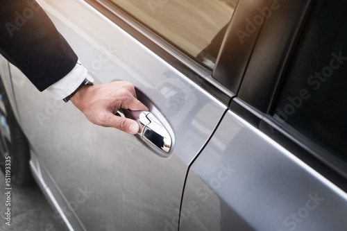 Chauffeur s hand on handle. Close-up of man in formal wear opening a passenger car door