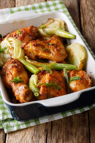 Hot chicken baked with fennel in a baking dish close-up. vertical