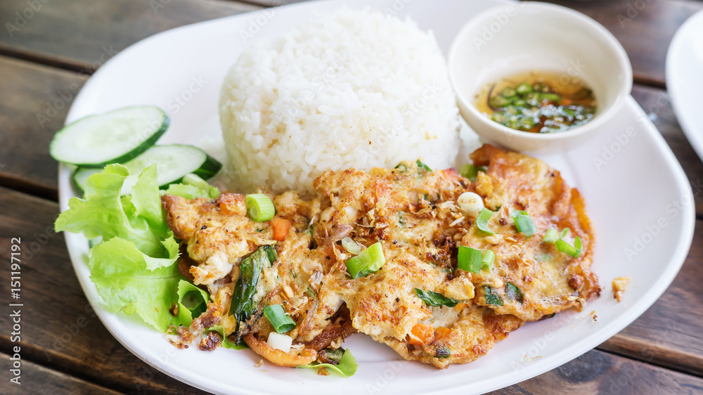 omelet (Thai style) with rice on a white plate.