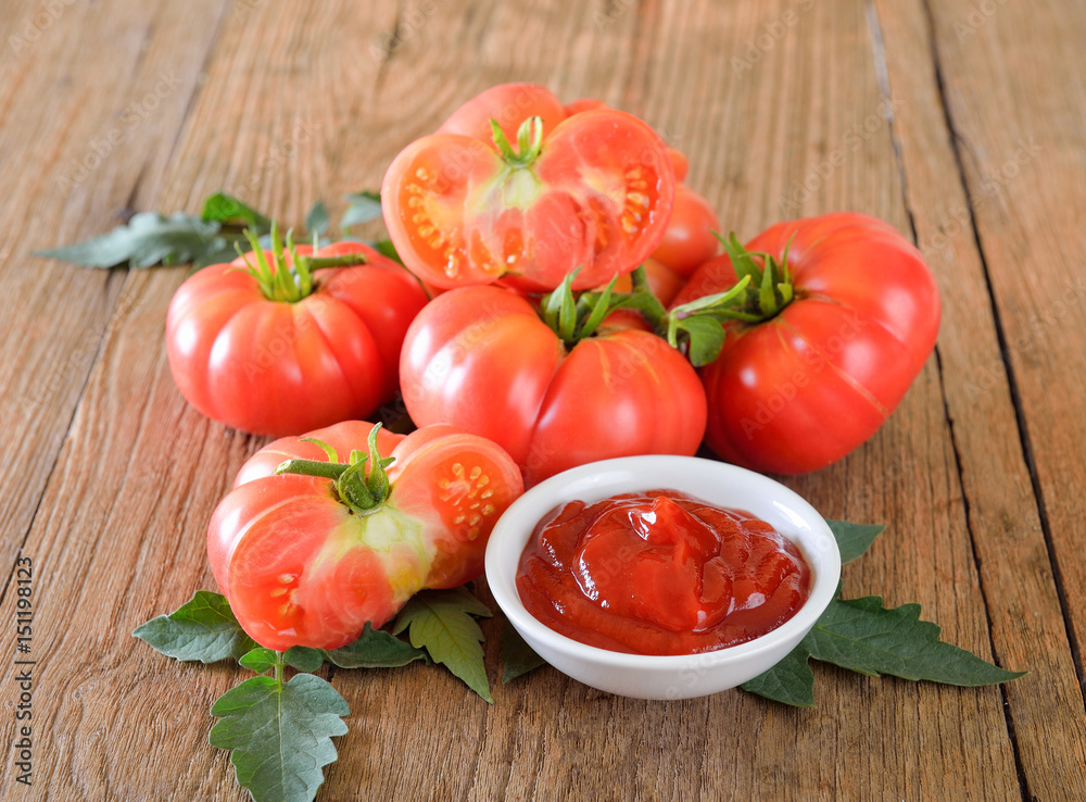 Fresh tomato and ketchup on wooden background Fresh tomato and ketchup on wooden background