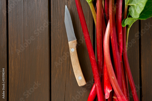 fresh rhubarb on wooden surface © Diana Taliun