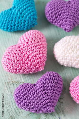knitted hearts on turuoise wooden surface