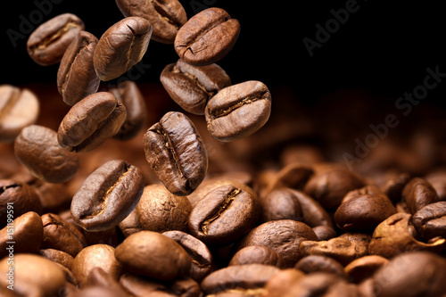 Falling coffee beans. Dark background with copy space, close-up photo