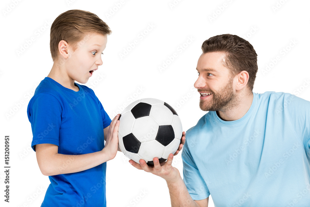 Portrait of father and son playing soccer isolated on white