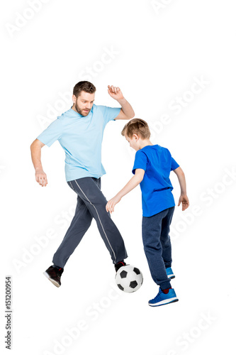 Young father and son playing soccer isolated on white