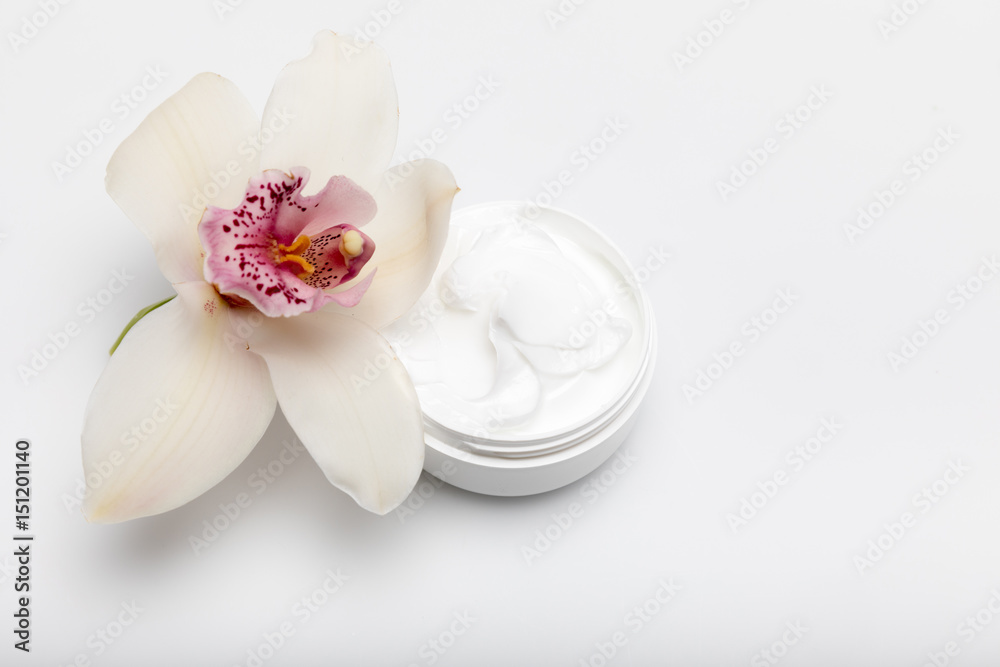 Close-up view of organic cream in container with orchid isolated on white Close-up view of organic cream in container with orchid isolated on white